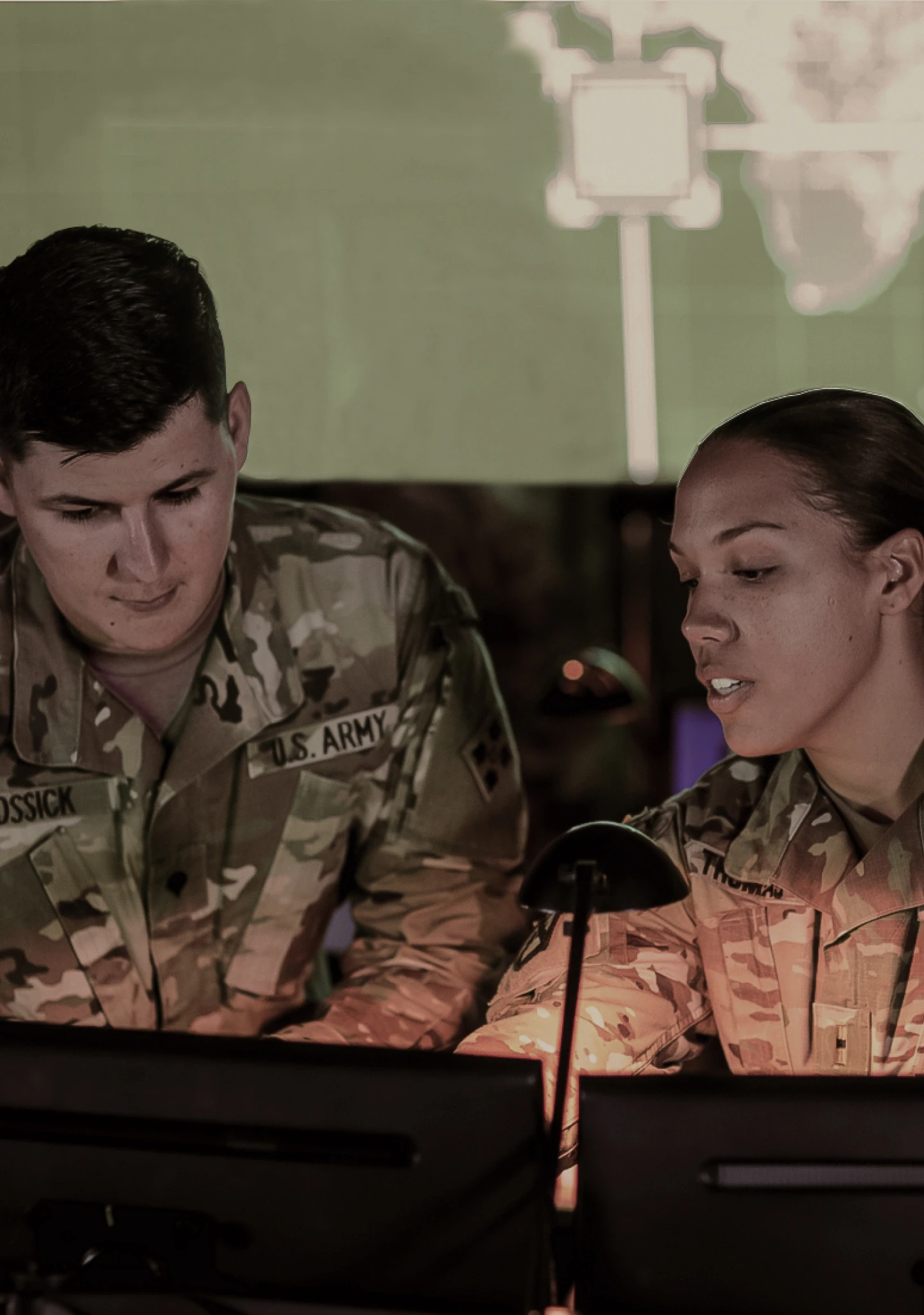 Dos Soldados en uniforme de combate trabajando en una computadora